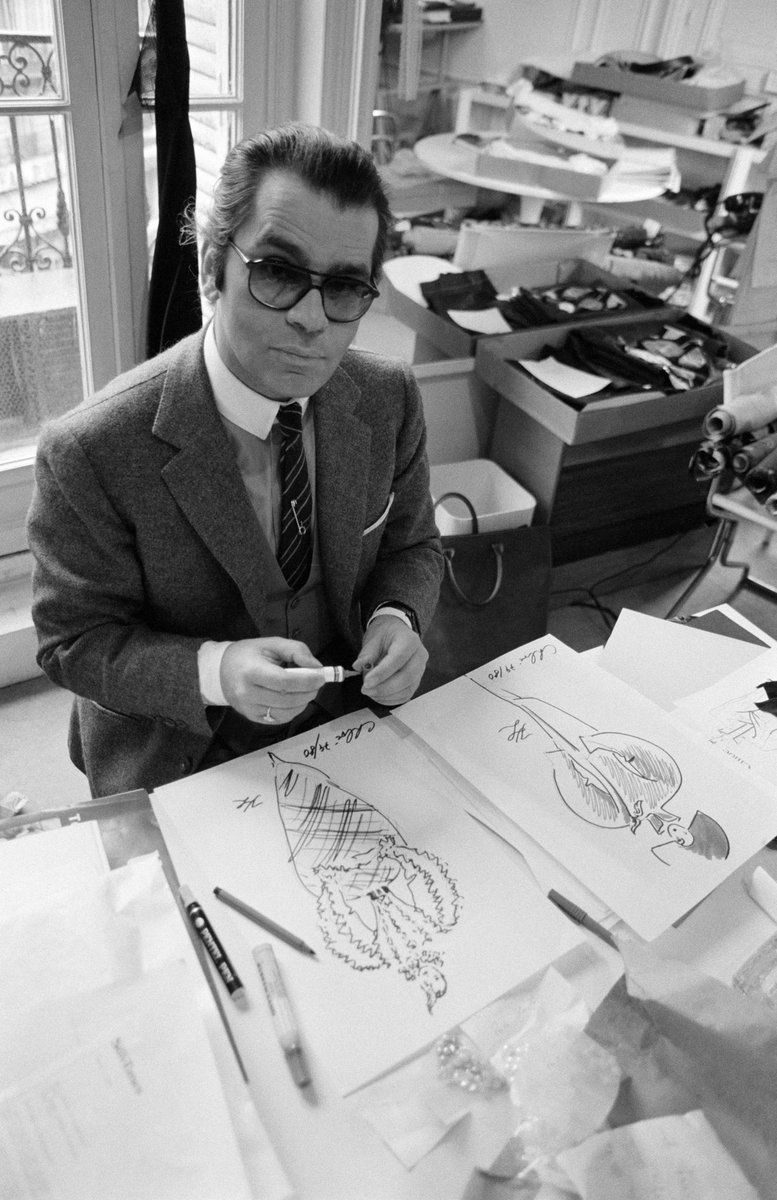 Historical fashion photography featuring Karl Lagerfeld drawing in his studio, showcasing the beginning of his enduring design legacy