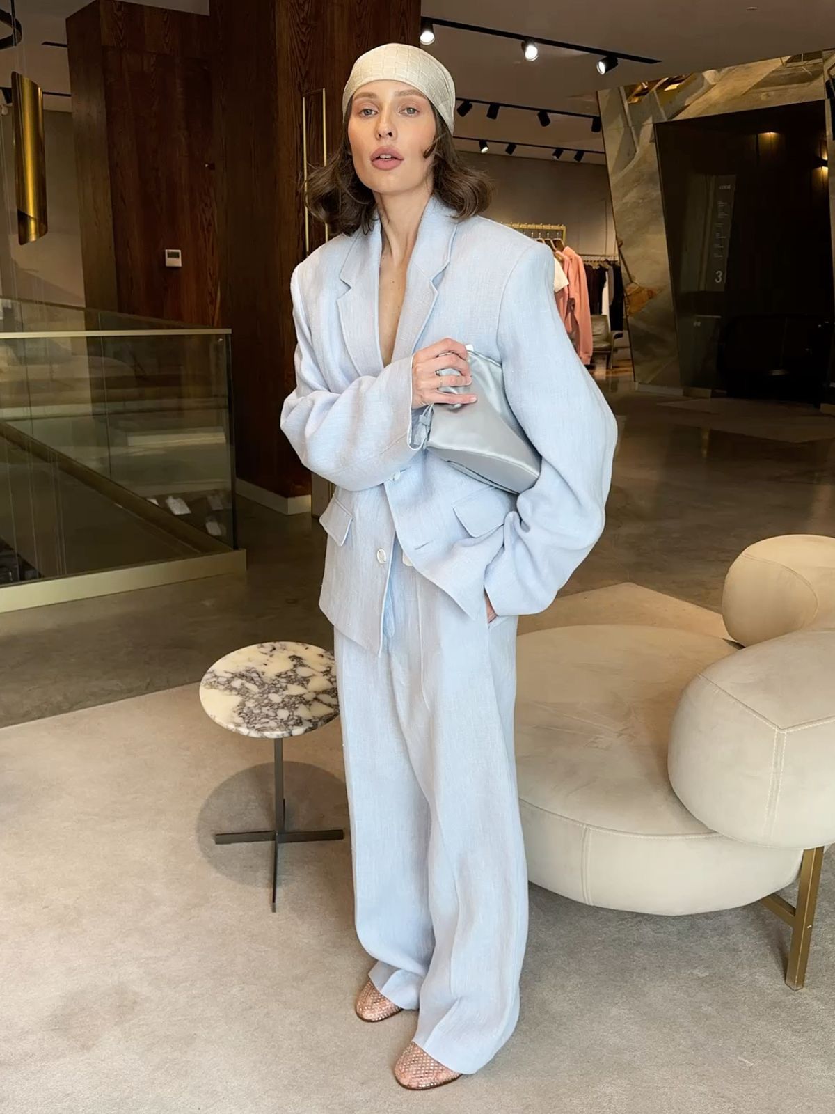 Modern minimalist street style featuring a monochromatic ice blue blazer and wide-leg trousers, styled with a chic headscarf and woven flats