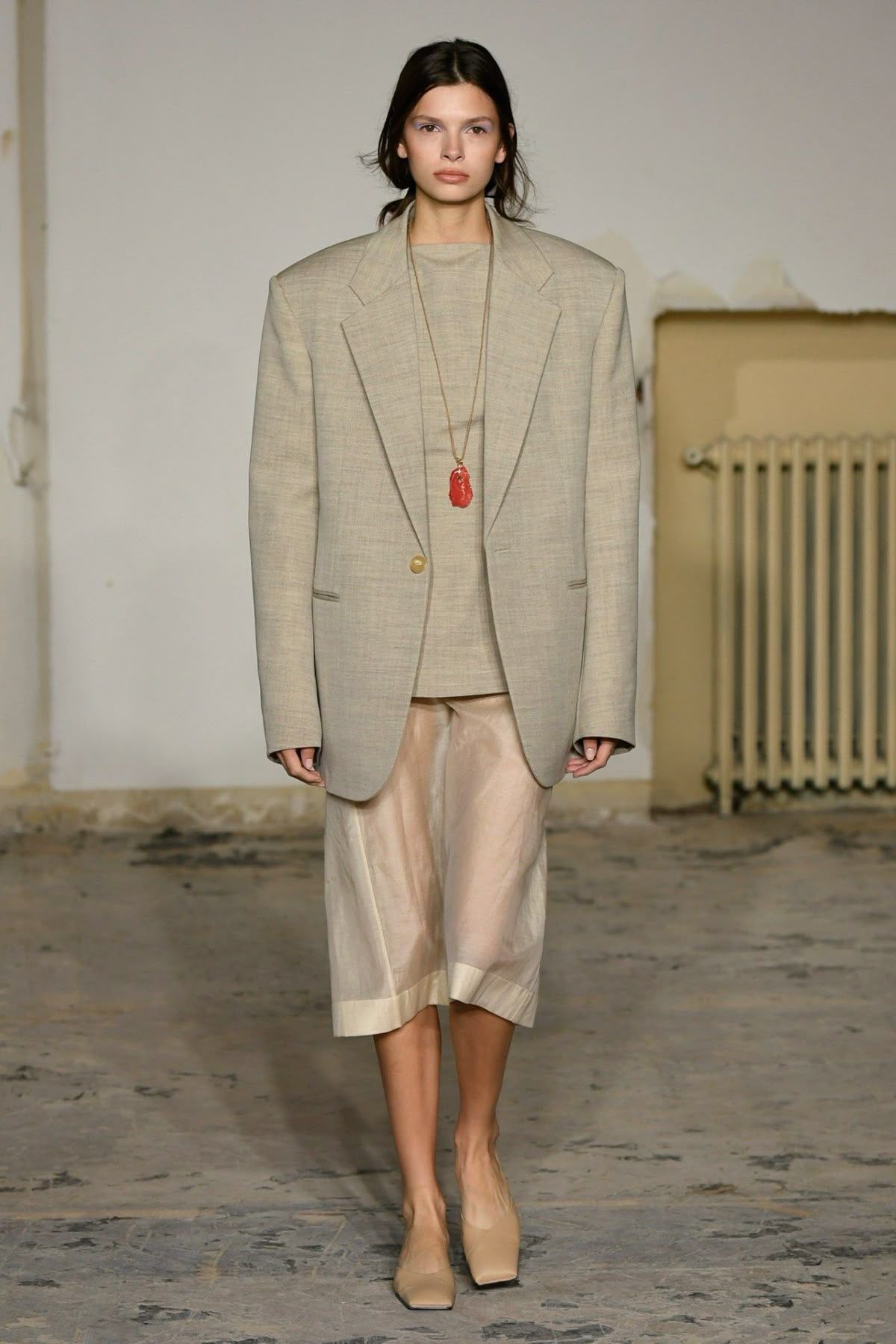 Carven runway look featuring an oversized beige blazer paired with a sheer midi skirt, demonstrating the perfect balance of masculine tailoring and delicate transparency