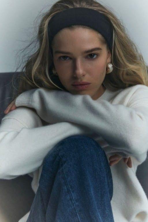 Iconic black elastic headband styling on a blonde model, showcasing the 90s off-duty supermodel hair trend and timeless French chic
